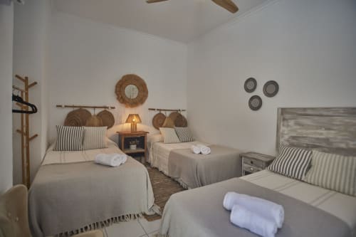 Habitación triple en Casas Cercana de Abarán con tres camas, almohadas a rayas, decoración tejida y ventilador de techo