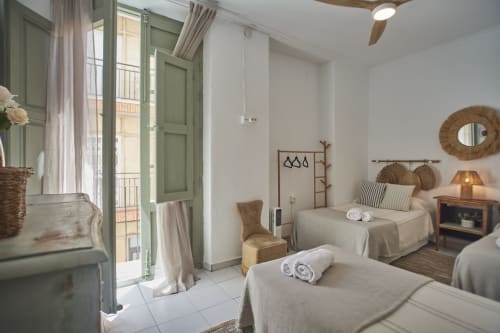 Luminosa habitación triple en Casas Cercana de Abarán con dos camas, puertas a balcón, decoración rústica y vistas a la ciudad