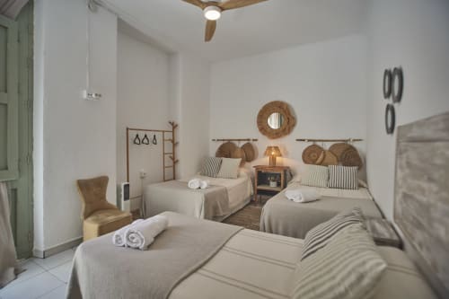 Habitación triple del hotel Casas Cercana en Abarán con tres camas, decoración tejida y ventilador de techo