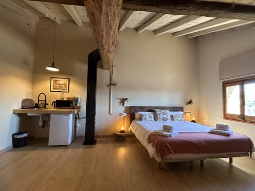 Habitación espaciosa en Casa Tapiolas B&B en Molló, Girona con cama, cocina americana y vigas de madera vista