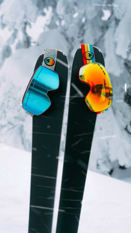 Gafas de esquí coloridas sobre esquís con fondo de montaña nevada, Casa Tapiolas cerca de Molló, Girona