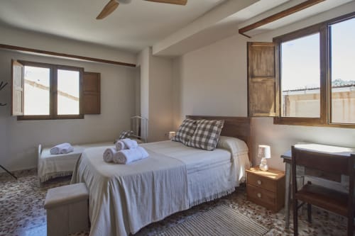 Luminosa habitación familiar en Casas Cercana de Abarán con camas dobles y sencillas, vigas de madera, ventanas con vistas al pueblo, y