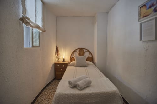 Acogedor dormitorio individual en Casas Cercana de Abarán con cabecero de madera, mesita de noche y luz natural