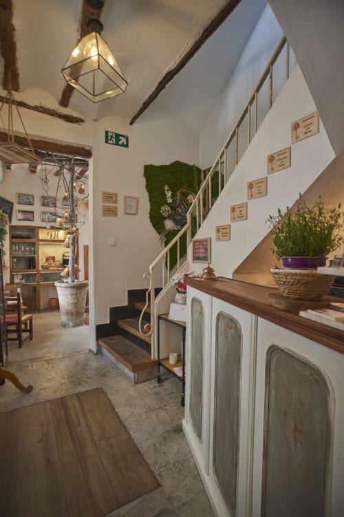 Escalera acogedora en la casa rural Casa Cercana con barandillas de madera, macetas y decoración rústica en Abarán