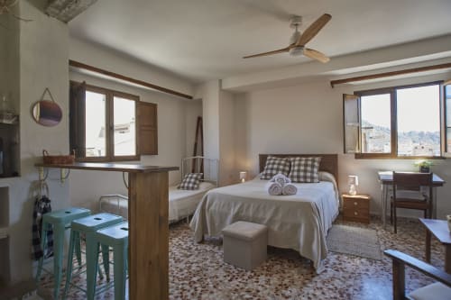 Espacioso dormitorio en Abarán con vistas a la ciudad, muebles de madera, cama de matrimonio, minicocina y ventilador de techo