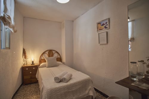 Acogedora habitación en la casita Casas Cercana de Abarán con cama individual, mesita de noche de madera e iluminación cálida