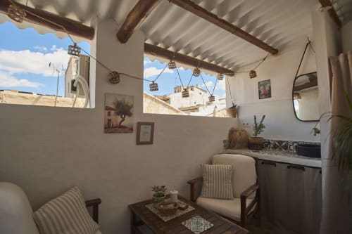 Interior de la cabaña Casa Cercana con vigas de madera, sillas a rayas y vistas de Abarán desde las ventanas