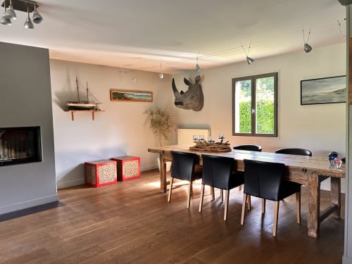 Salle à manger moderne du gîte Mon Week End A La Mer à Hautot-sur-Mer avec table en bois, chaises noires et vue sur la rivière