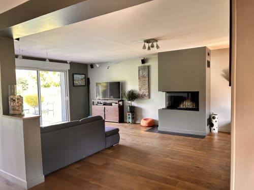 Séjour moderne avec cheminée, téléviseur, canapé et portes vitrées ouvrant sur le jardin du gîte Mon Week End A La Mer