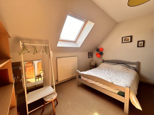 Chambre mansardée lumineuse avec lucarne, lit en bois, armoire, radiateur et vue sur la rivière au cottage Mon Week End A La Mer