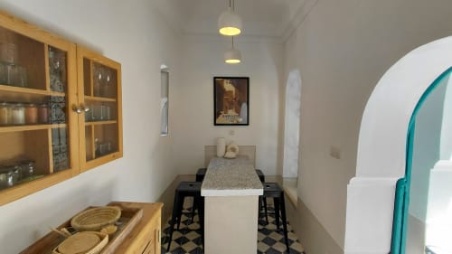 Modern dining area in Riad Dar Kleta apartment with wooden shelving, black bar stools, and turquoise archway in Marrakech