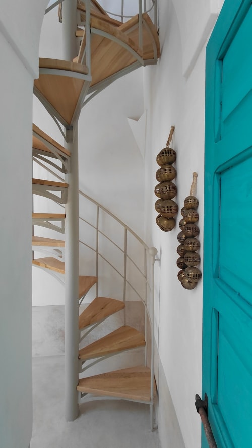 Spiral staircase with wooden steps and metal railings in Riad Dar Kleta, Marrakech apartment