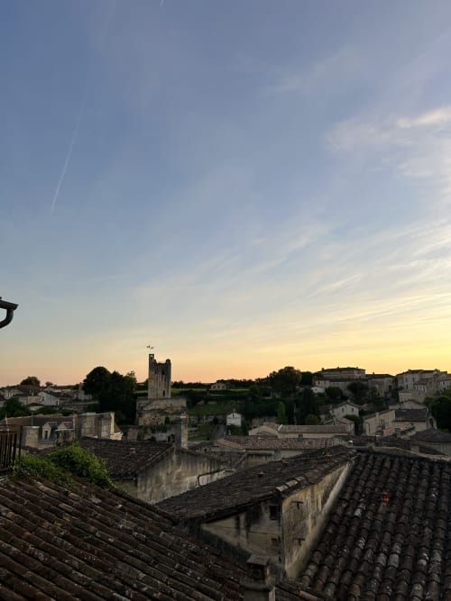 Sunset view of historic Saint-Émilion village with stone church tower and traditional tile roofs from La Maison du Clocher
