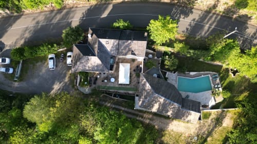 Vue aérienne du Gîte Le Moulin D'Olt à La Canourgue, France, avec bâtisses en pierre, piscine et verdure environnante