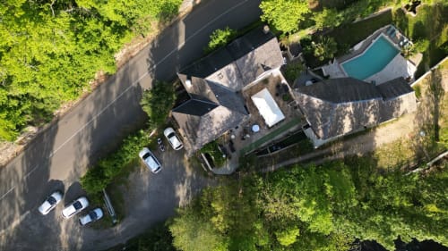 Vue aérienne du Gîte Le Moulin D'Olt avec piscine, terrasse et voitures garées, entouré de verdure à La Canourgue