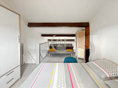 Studio duplex moderne à L'Île-Rousse avec chambre mezzanine, literie rayée et escalier vers l'espace sommeil
