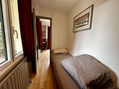 Chambre triple à l'Hôtel la Source à La Foux avec lit, fenêtre, parquet et accès au couloir