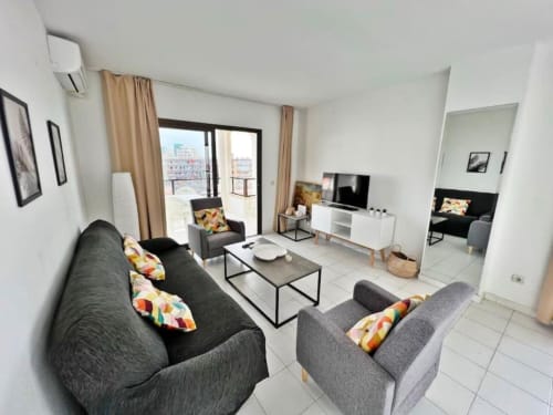 Moderno apartamento de 2 dormitorios en Fuengirola con vistas al mar, sofás grises, balcón y todas las comodidades