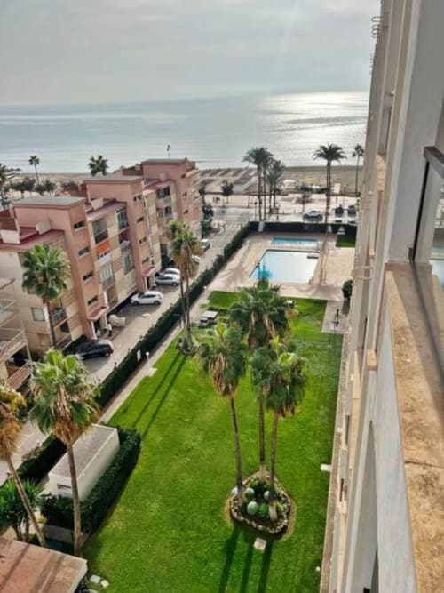 Complejo residencial frente al mar en Fuengirola con vistas al océano, piscina, jardines exuberantes y palmeras