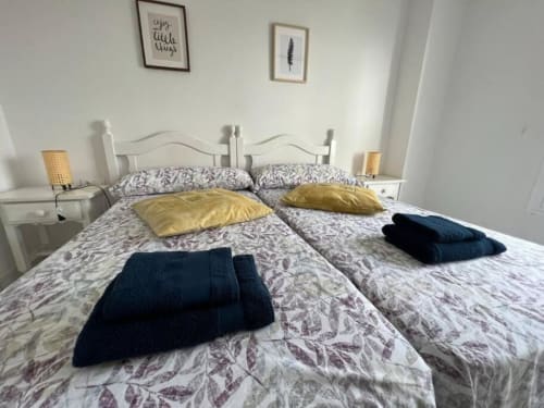 Moderno apartamento de 2 dormitorios en Fuengirola con camas gemelas, ropa de cama estampada, almohadas doradas y vistas al mar