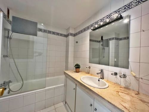 Baño moderno con doble lavamanos, bañera y ducha en apartamento de 2 dormitorios en Fuengirola por Grupo Inmohouse