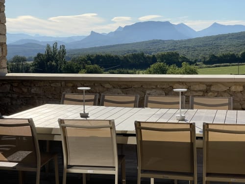Terrasse extérieure avec vue sur les montagnes du Domaine Maison Girardon, chaises et tables de repas dominant la vallée de la Drôme