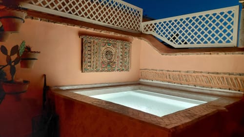 Rooftop plunge pool at Riad Dar Kleta in Marrakech with terracotta walls, white lattice screens, and decorative tile artwork