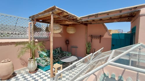 Terrace with wooden pergola, potted plants, and lounge seating at Riad Dar Kleta in Marrakech