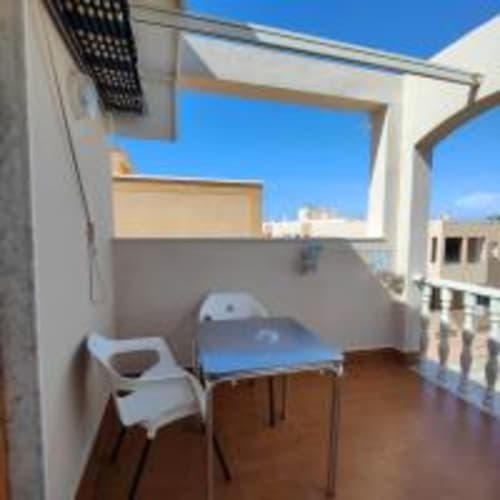 Habitación Superior Individual con terraza en Hostal las Dunas, Cabo de Gata Almería, con cama, silla y cielo azul despejado
