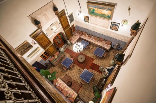 Vue aérienne de la cour traditionnelle du Riad Dar Tahri à Fès avec sièges, fontaines et décoration marocaine