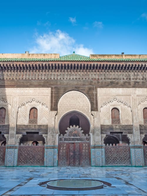Cour du Riad Dar Tahri à Fès présentant une architecture marocaine traditionnelle avec toit aux carreaux verts et zelliges ornementaux