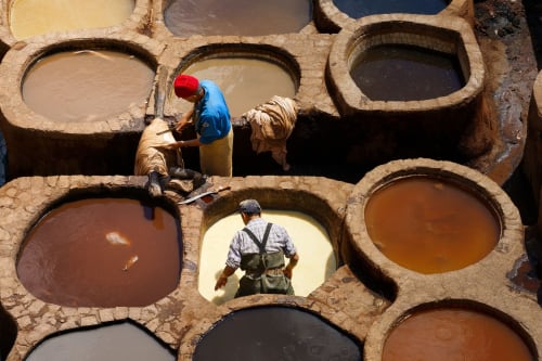 Ouvriers tanneurs aux cuves de tannage à Fès, Maroc près du Riad Dar Tahri