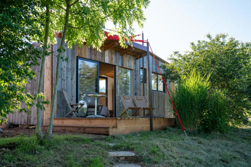 Charmante cabane en bois aux Cabanes de Julie à Lissac et Mouret, entourée de verdure luxuriante avec terrasse