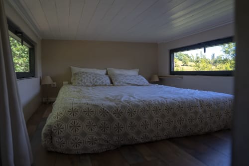 Chambre lumineuse avec literie à motifs aux Cabanes de Julie, hébergement en cabane perchée à Lissac et Mouret, France