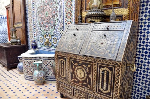 Salle de bains marocaine traditionnelle au Riad Dar Tahri à Fès avec zellige ornementé, boiseries sculptées et éléments décoratifs