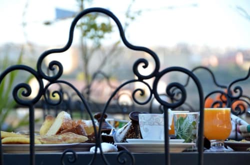 Petit-déjeuner au Riad Dar Tahri avec ferronneries ornementales, pâtisseries et jus d'orange surplombant la cour de Fès