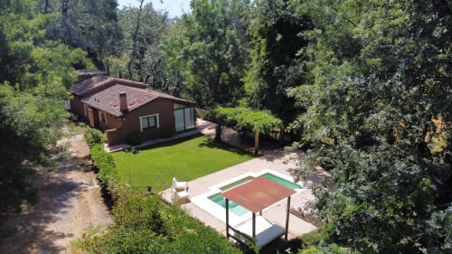 El Escondite De Pedro Malillo B&B in Candeleda with red-roofed cottage, tennis court, and surrounding forest
