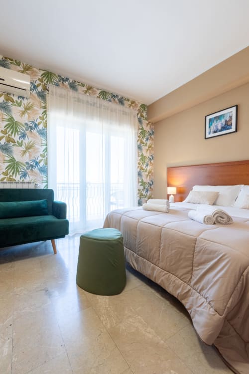 Camera luminosa a La Zagara Rooms a Milazzo con letto matrimoniale, balcone con vista sul mare e arredi moderni