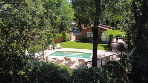 Serene pool area surrounded by lush trees at El Escondite De Pedro Malillo, a boutique B&B in Candeleda, Spain