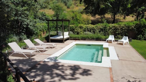 Outdoor pool at El Escondite De Pedro Malillo in Candeleda with loungers, canopy bed, and lush gardens