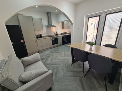 Modern open-plan kitchen and lounge at 2 Doves Holiday Property in Exeter with grey herringbone flooring