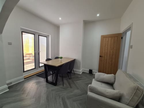 Modern open-plan living area at 2 Doves Holiday Property, Exeter with dining table, sofa, and patio doors