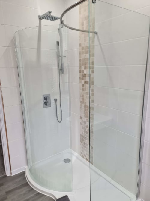 Modern curved glass shower enclosure with rainfall showerhead at 2 Doves Holiday Property, Exeter