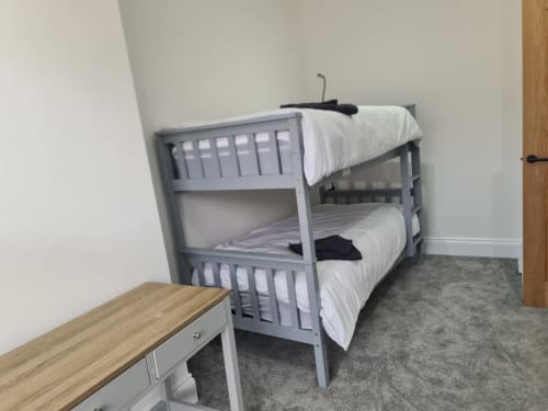 Gray bunk bed with white bedding in a bedroom at 2 Doves Holiday Property, Exeter