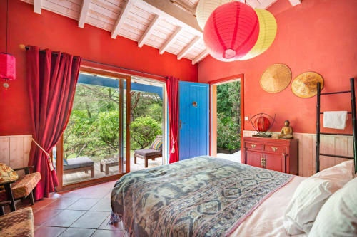 Chambre rouge éclatante au Moulin de Lassalle avec portes donnant sur la piscine, décoration traditionnelle et cadre de la campagne française à Linxe