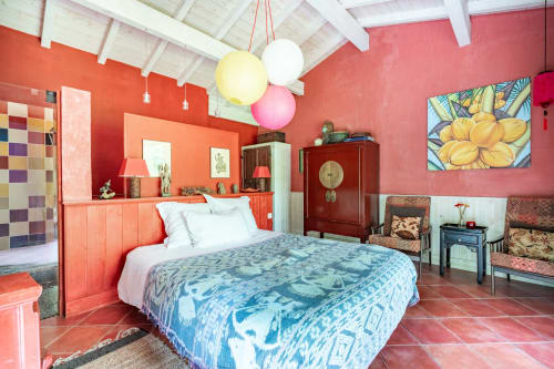 Chambre lumineuse au Moulin de Lassalle avec murs corail, literie bleue à motifs et mobilier vintage à Linxe, France