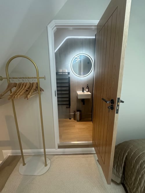 Modern ensuite bathroom at 2 Doves Holiday Property in Exeter with illuminated mirror and contemporary fixtures