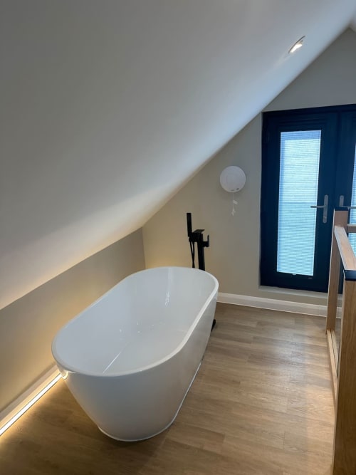 Modern freestanding bathtub in luxury bathroom at 2 Doves Holiday Property, Exeter with ambient lighting and contemporary