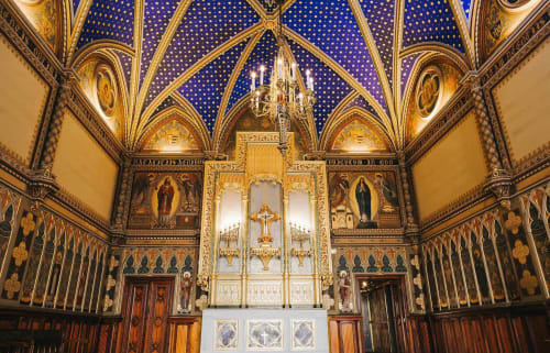 Capilla gótica ornamentada con techo de estrellas azules, detalles dorados y altar de cruz iluminado en La Caseta de Ròtova