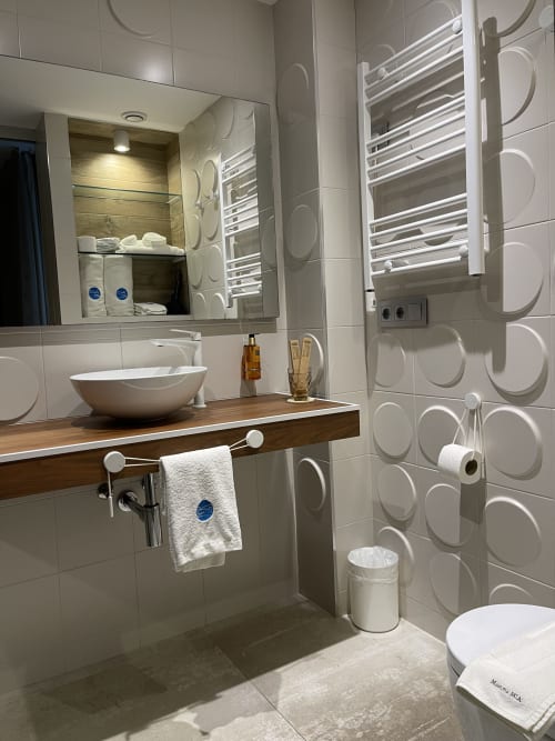 Baño moderno del Hotel Boutique Mamma Mia Tossa con lavamanos tipo vessel, toallero calefaccionado y diseño en azulejos blancos